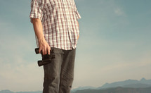 torso of a man holding binoculars 
