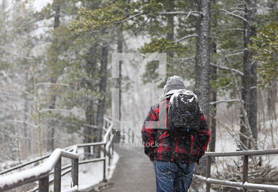 man backpacking in snow 