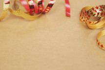 Shiny Christmas ribbon creates a border on brown paper.
