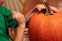 boy carving a pumpkin 