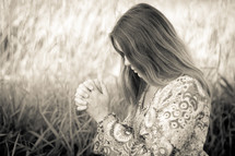 woman praying in a field 