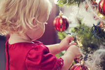 toddler hanging Christmas ornaments 