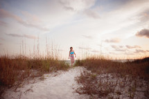 girl child walking on a sandy path 