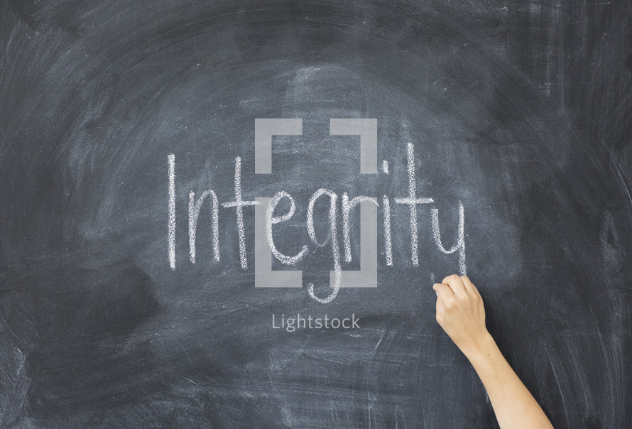 writing the word integrity on a chalkboard 