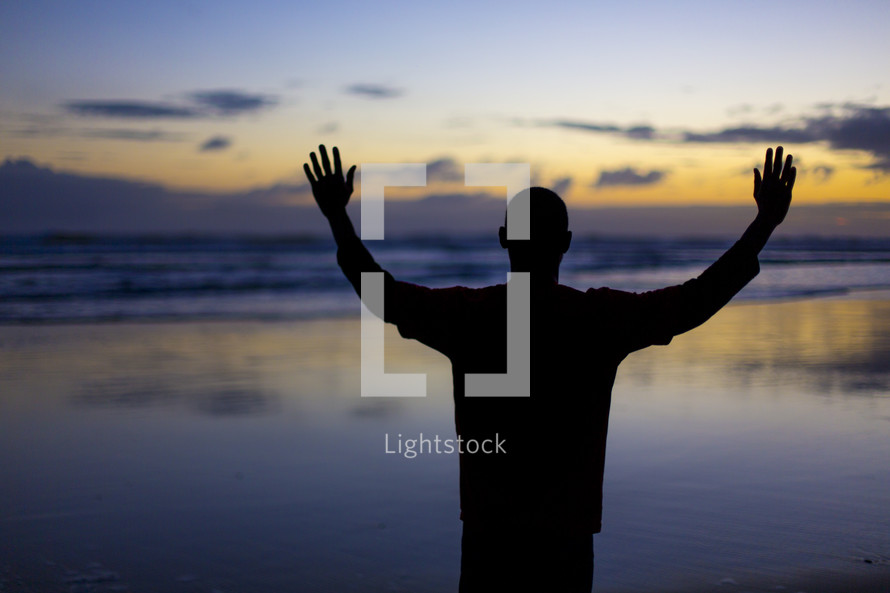 silhouette of a man with raised arms 