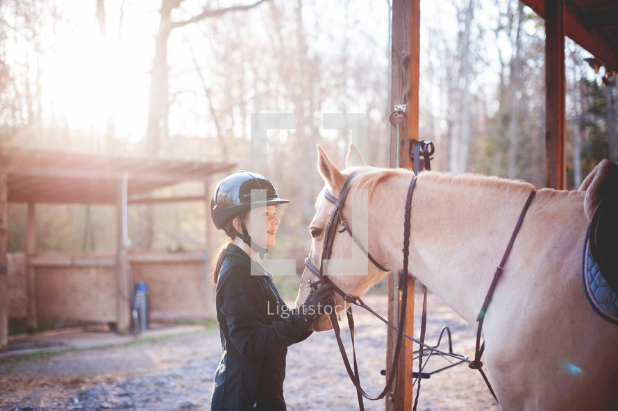 teen girl with her horse in a stable 