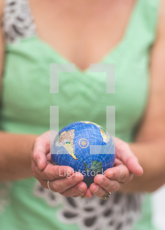 woman holding a small globe 