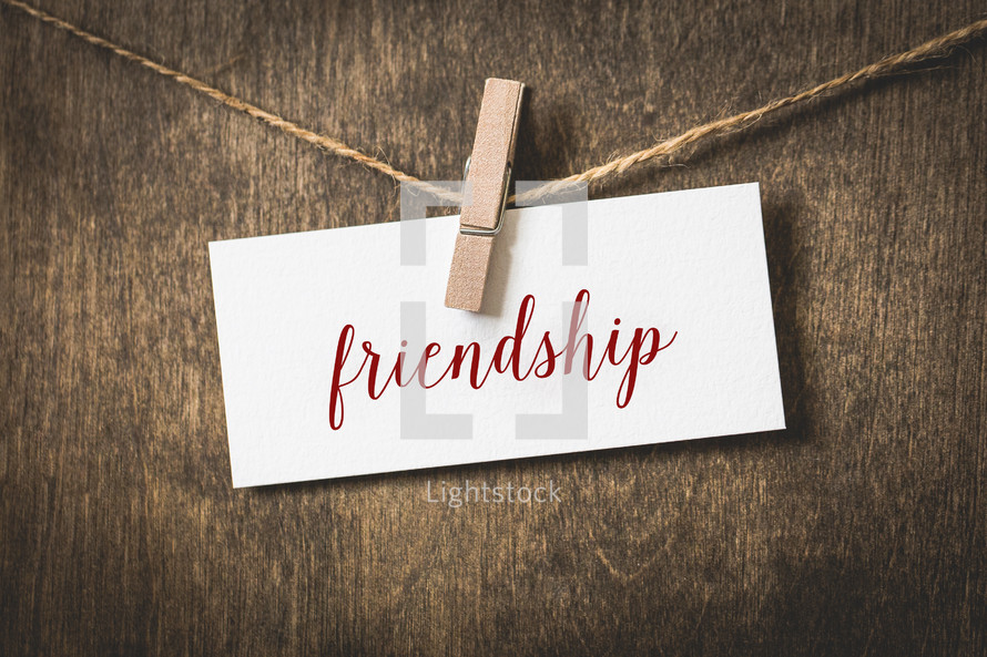 word friendship on white card stock hanging on a clothesline of twine