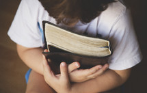 child holding a Bible 