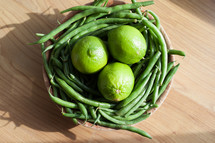 limes and green beans in a bowl 