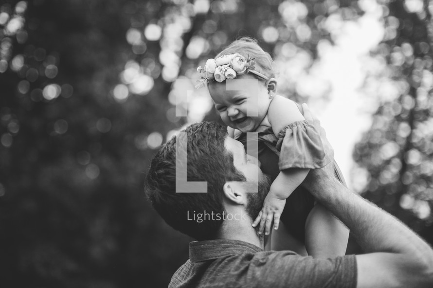 a father lifting up his daughter 