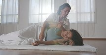 Shiatsu treatment. Masseuse pressing and massaging the back and the shoulders of woman