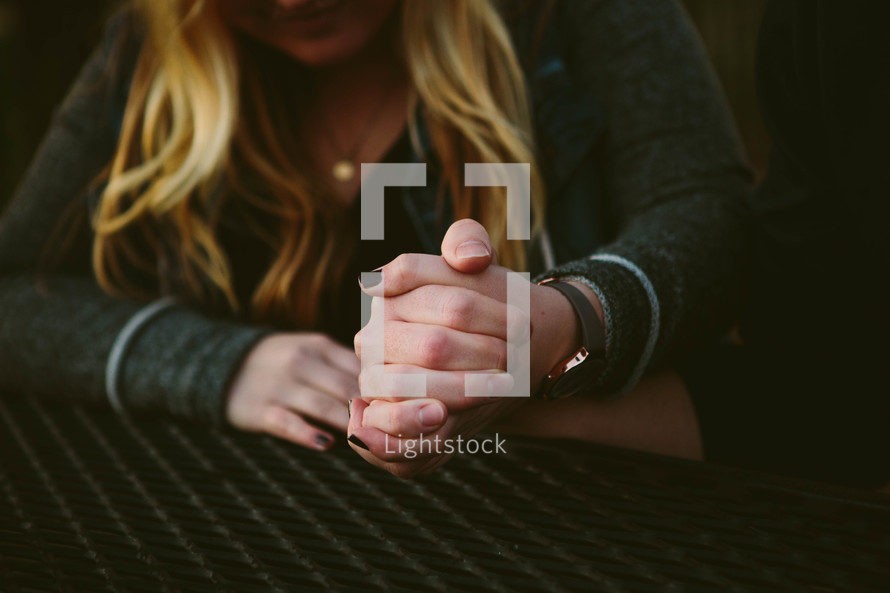 a couple holding hands sitting at a table 