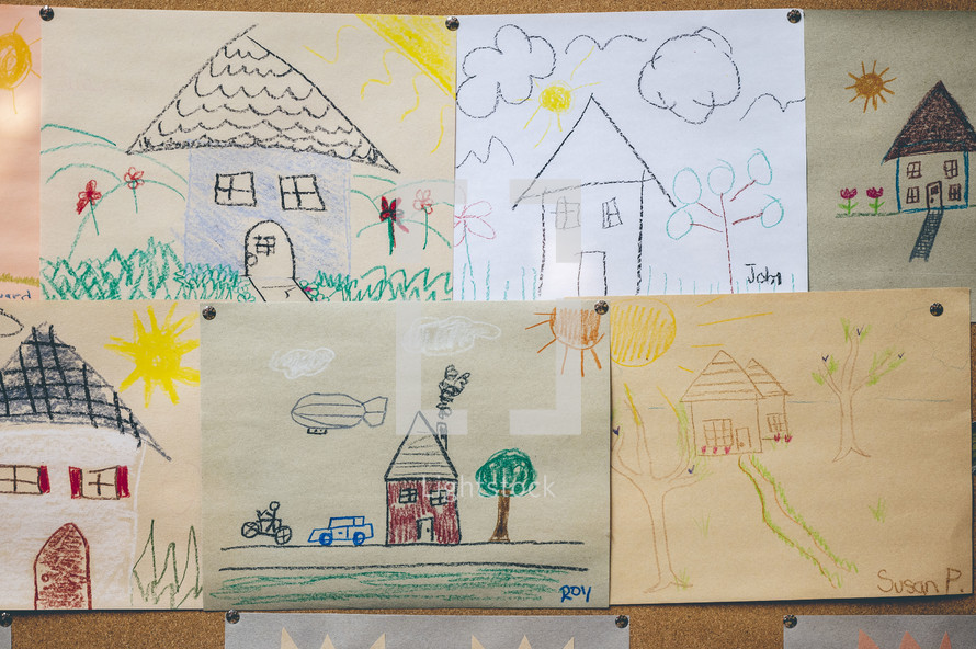 children's drawings of house on a cork board 