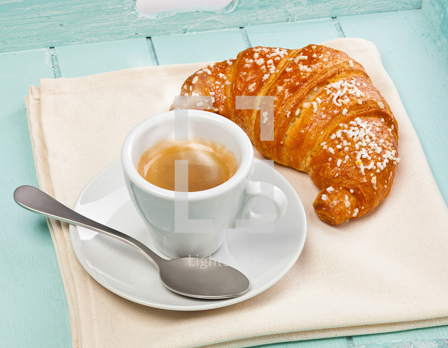 Espresso coffee with croissant in wooden tray light blue.