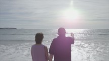 a man and woman on a beach at sunrise 