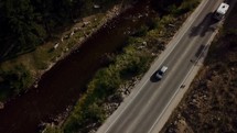 drone shot over a car traveling on a road 