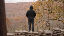 Unrecognizable Man with Black Jacket Standing on the Mountain Peak Facing to the Valley of Autumn Fall Foliage Trees Arkansas for Inspiration