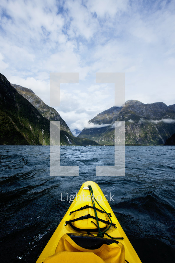 Front of a kayak on the open waters heading toward the mountains