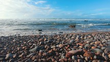 Rocky beach summer holiday background, slow motion of waves in ocean coast