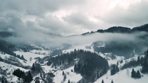 Aerial view of misty rural country with grey foggy clouds in forest nature in winter
