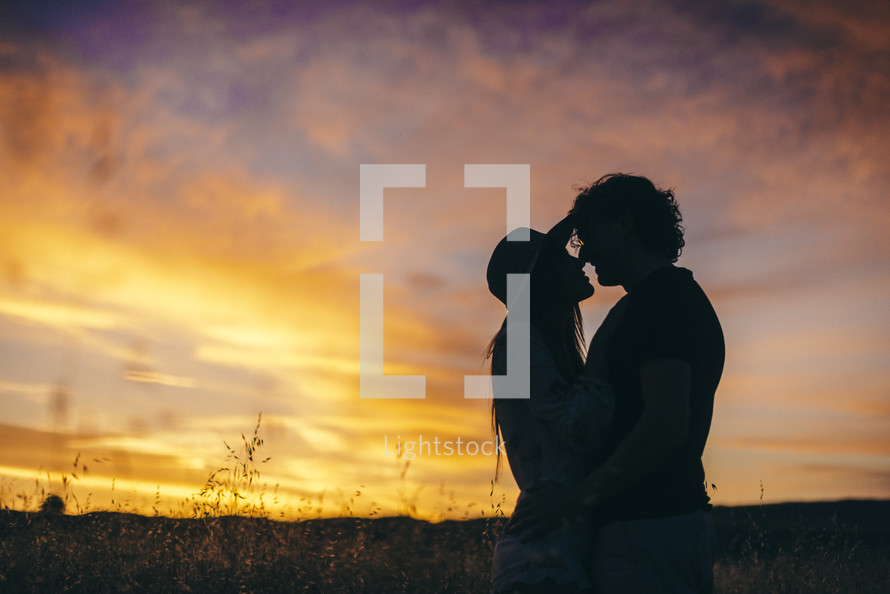silhouette of a couple kissing at sunset 