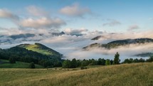 Peaceful foggy morning with clouds moving over beutiful landscape in mountains. Time lapse Zoom in
