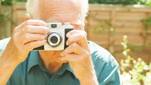 Senior taking photographs with a vintage camera