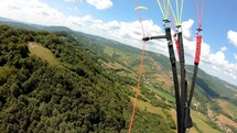 Adventure paragliding above green country in summer.
