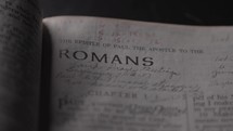 Light revealing a Bible and the book of Romans