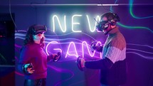 A woman and a man face each other playing a virtual reality game.
