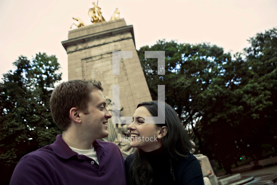 Couple sitting in front of a monument smiling