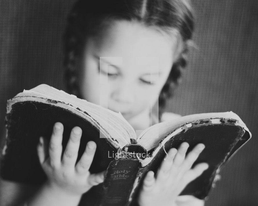 Little girl reading the bible 