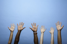 raised hands against a blue background 