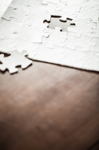 White jigsaw puzzle with one pieceout of place.