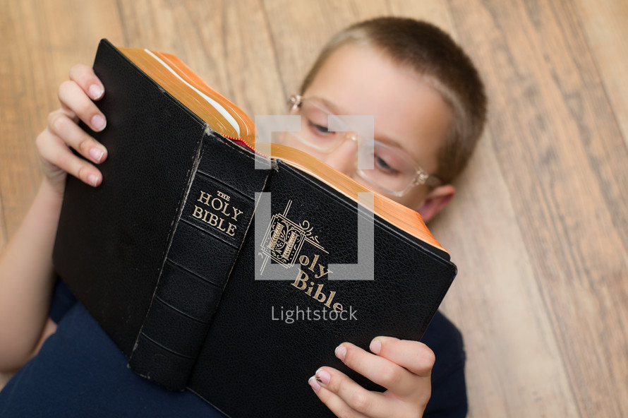 A boy child reading a Bible 