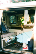 messy van interior with surfboard 