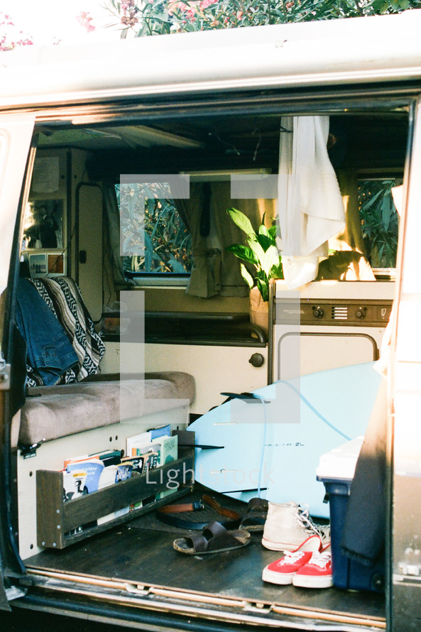 messy van interior with surfboard 
