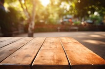 Wooden table top on blur background of city park with bokeh.
