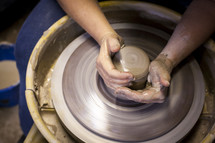 shaping clay on a potter's wheel 