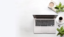 Laptop computer with coffee cup and plant on white background, top view