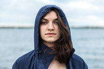 face of a brunette young woman in a hooded jacket 