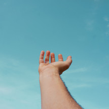 hand up gesturing in the blue sky