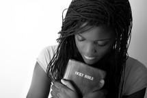 A teen girl holding a Bible. 