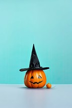 Halloween pumpkin with witch hat on blue background, halloween concept