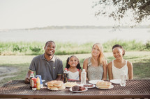 a family sitting at a picnic table 