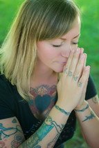 tattooed hands praying 