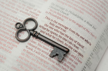 key lying on the pages of a Bible