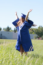 a student dances with joy on graduation day outside her school
