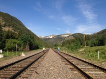 two people walking on two sets of tracks